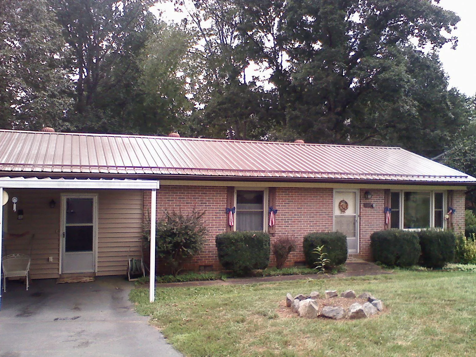 Bronze metal roof and carport on a brick ranch home — Roof Repair work by our crew in Statesboro