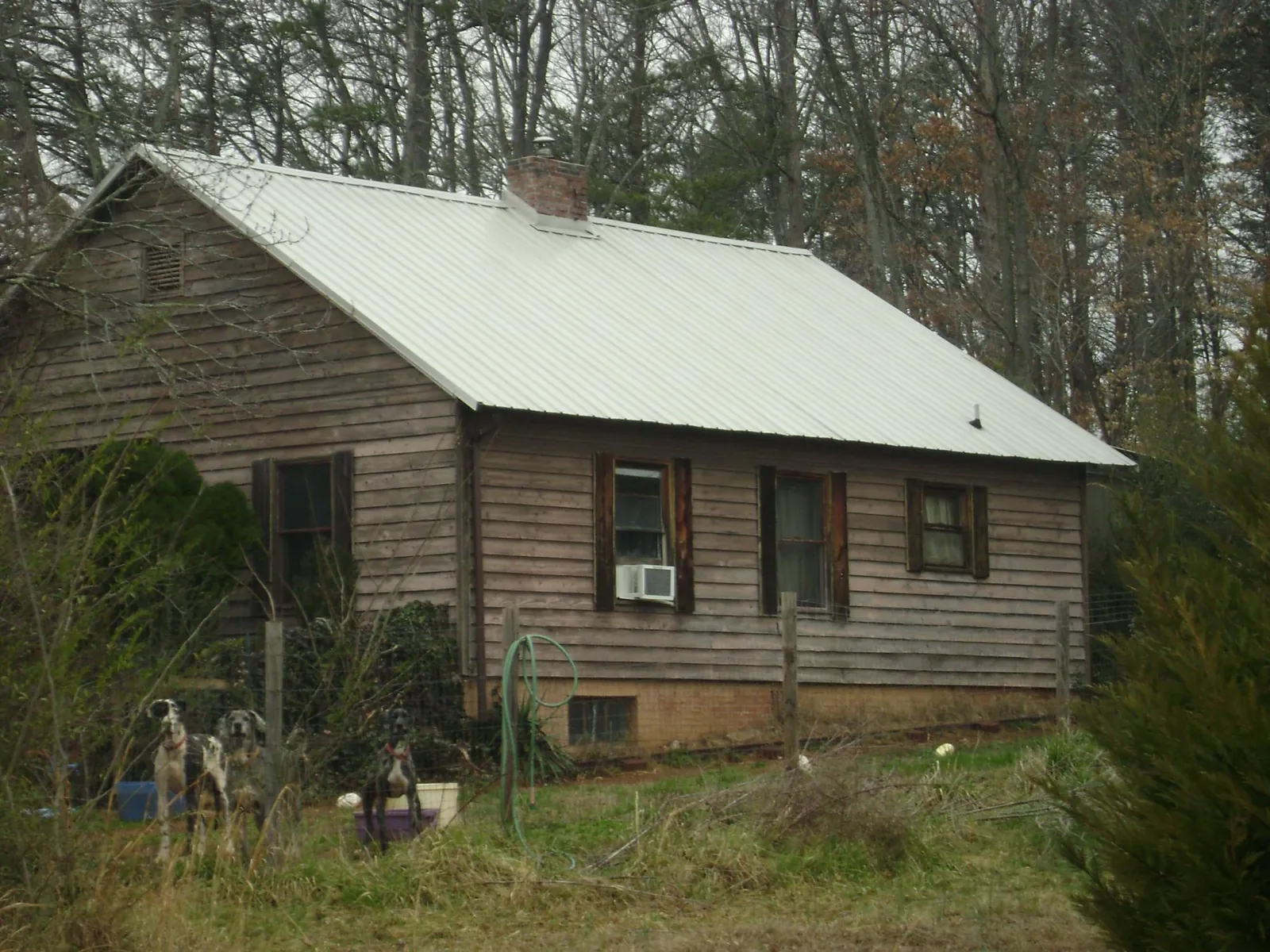 White metal roof on an old wood sided farmhouse, from a Asphalt Shingle Roof Repair job in Statesboro